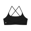 A black sports bra with a square neckline and crisscrossing thin shoulder straps, shown flat. A small circular silver logo is printed on the lower left side.
